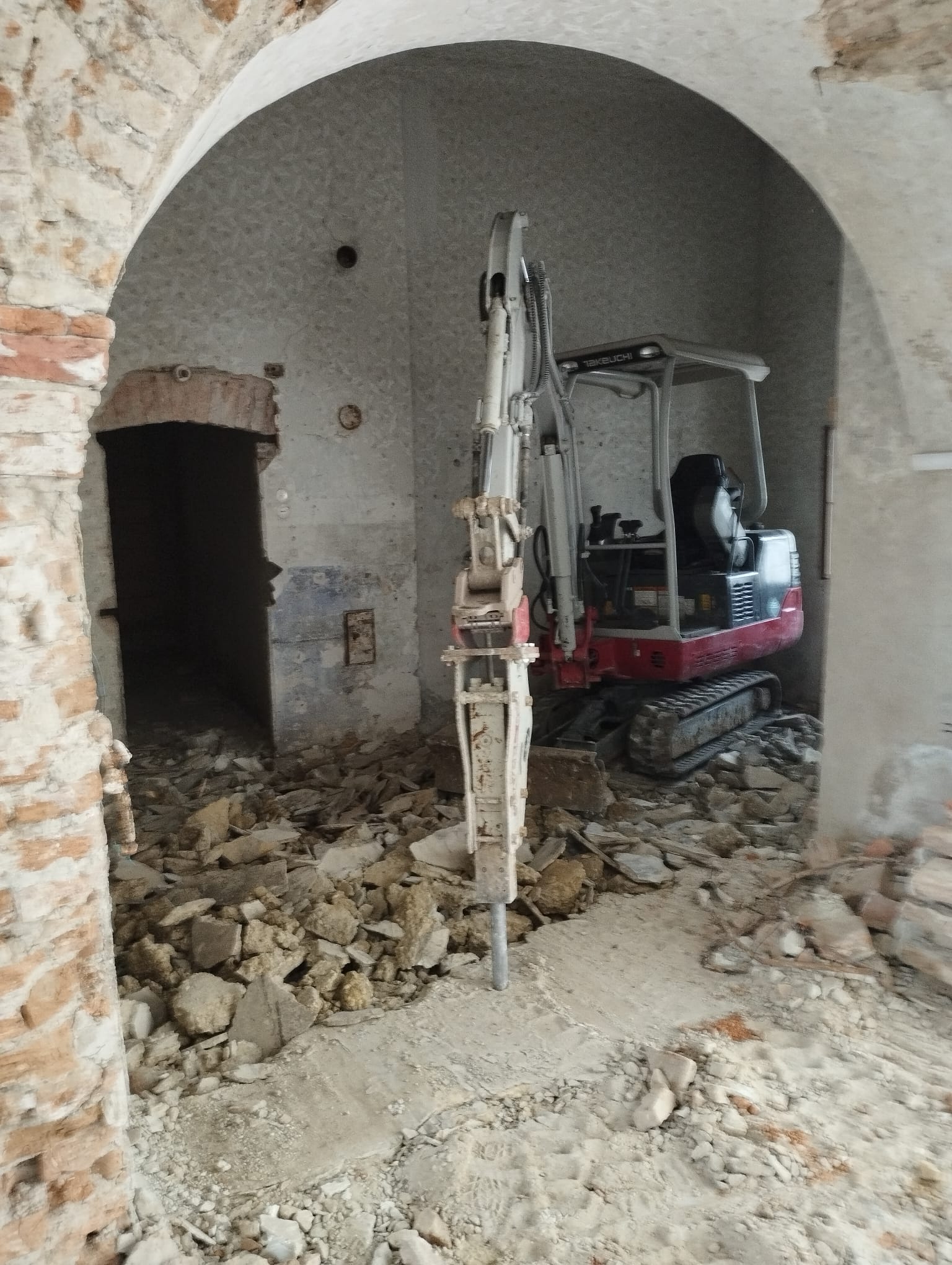 Takeuchi-Minibagger beim Abbruch im gewölbten Innenraum eines Altbaus