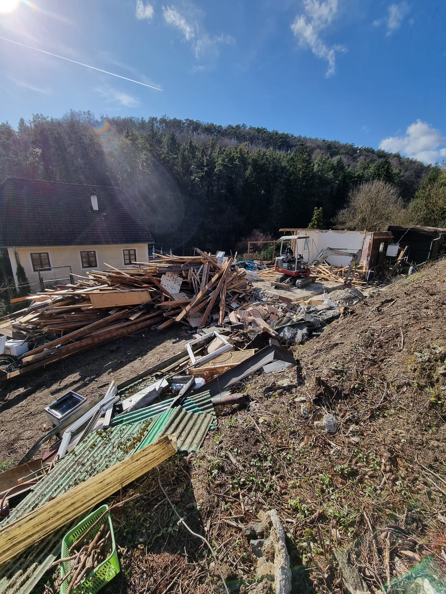 Großer Trümmerhaufen nach dem Abriss eines Kleingartenhauses am Waldrand